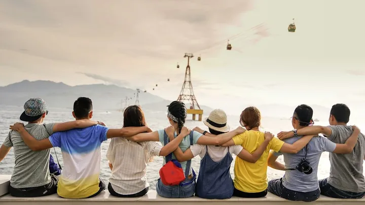 A group of friends sitting together looking out over a city